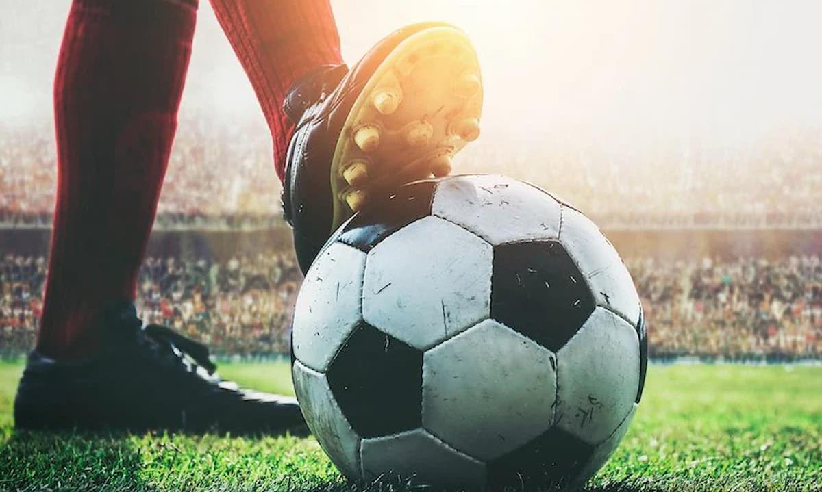 soccer player holding ball with foot