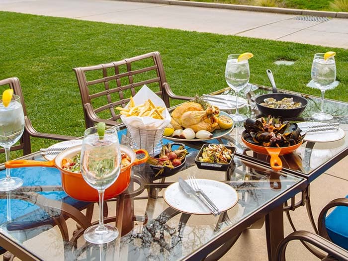 Outdoor table filled with food and wine