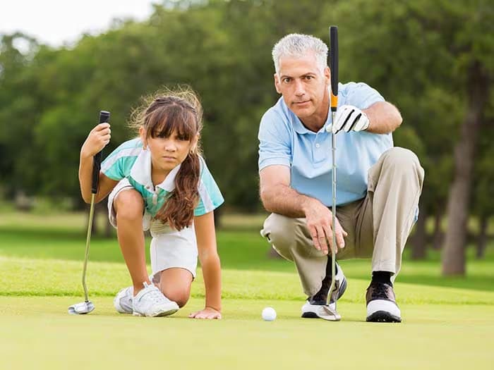 daughter and father playing golf
